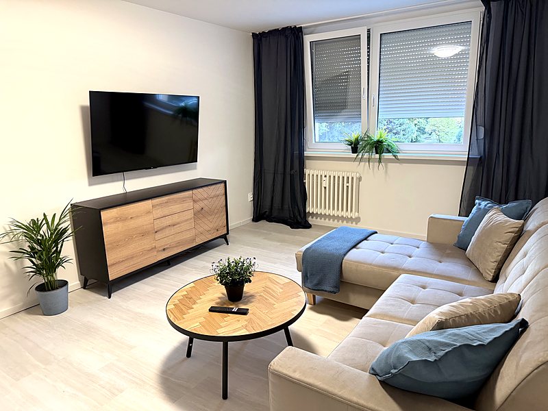Obývačka s rohovou sedačkou a Smart TV s Netflixom